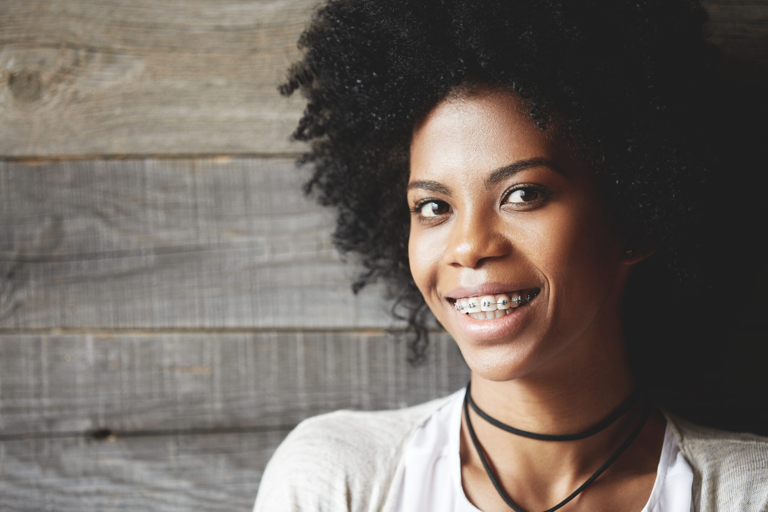 Adult woman wearing braces, smiling at camera